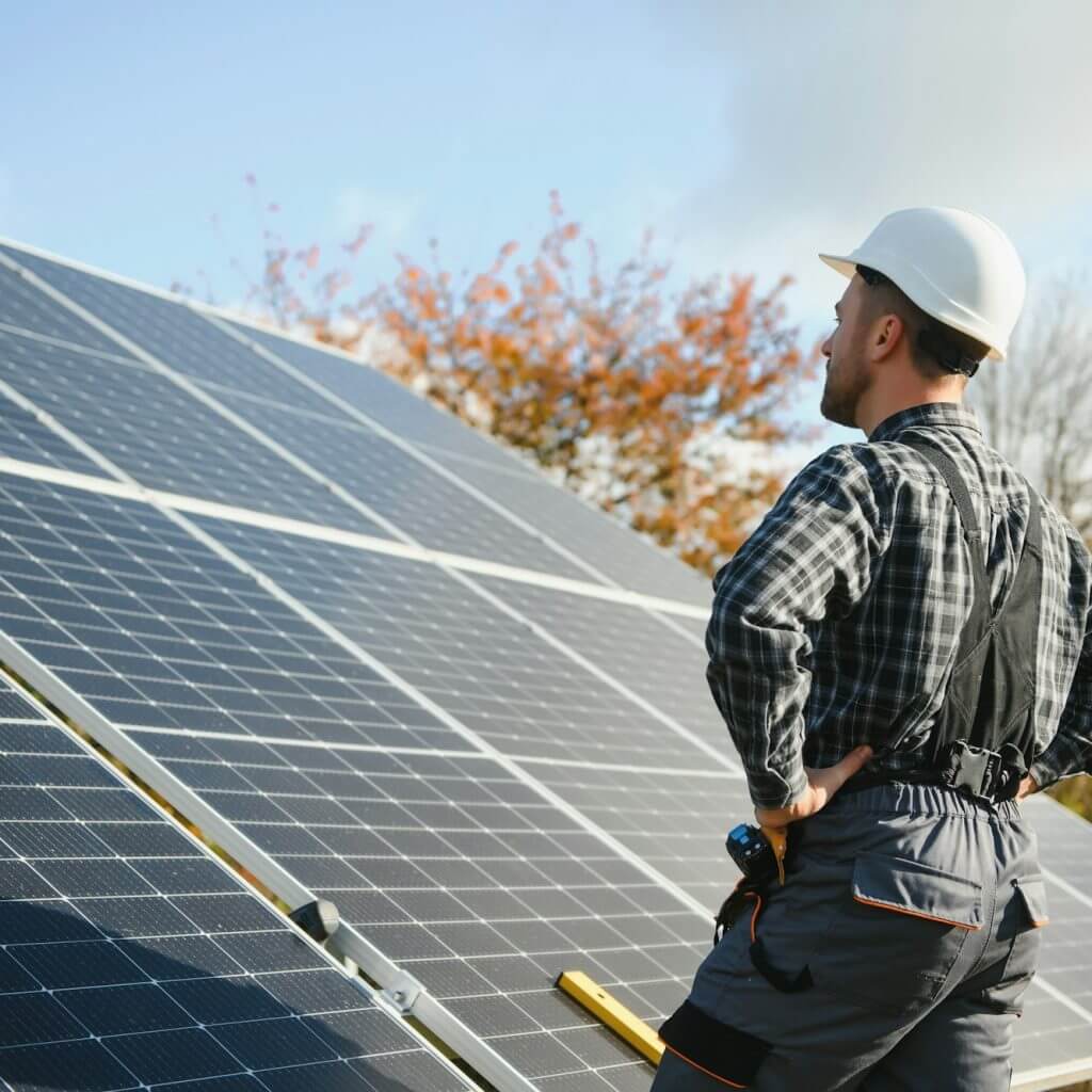 Professional worker installing solar panels on the metal construction