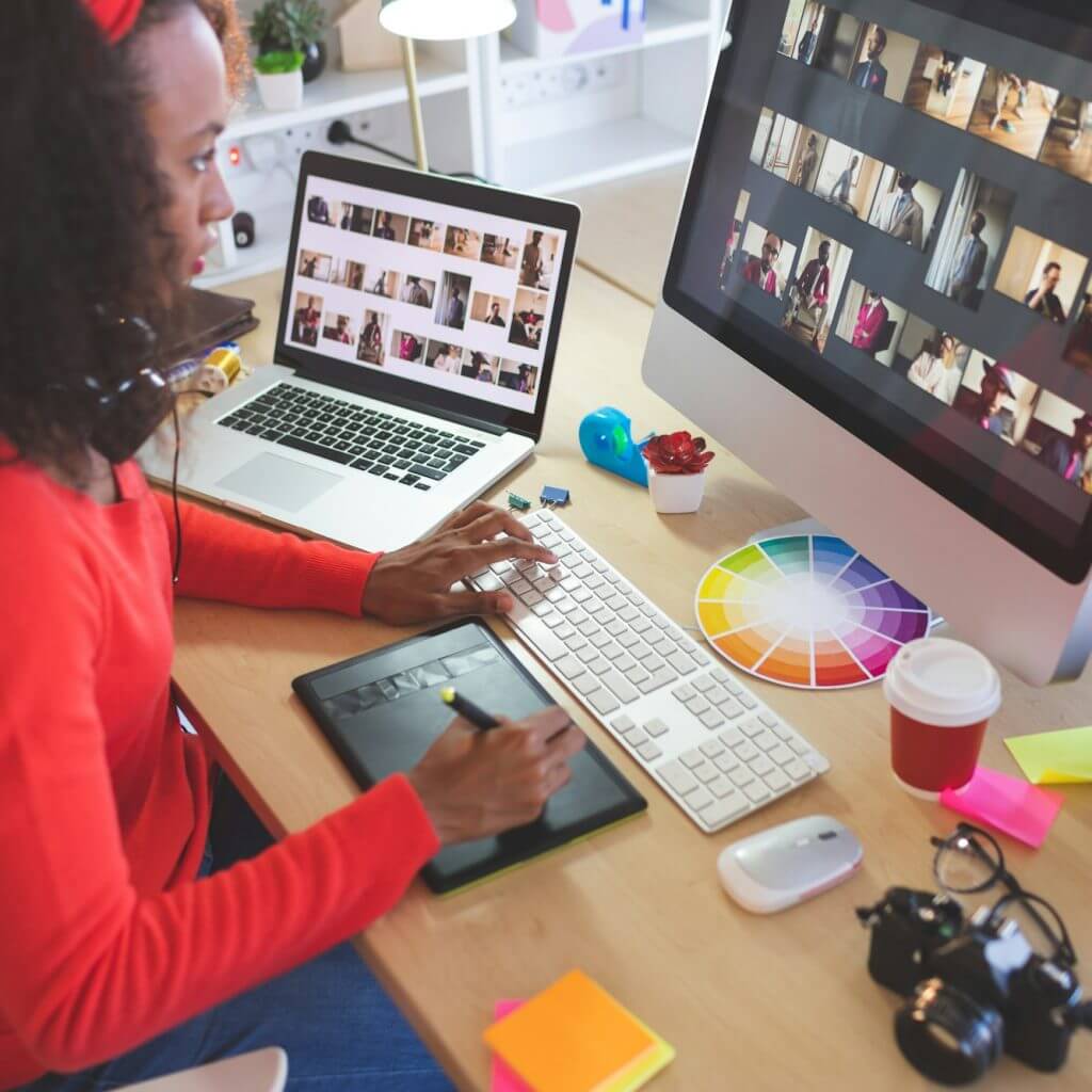 Female graphic designer using graphic tablet at desk in a modern office